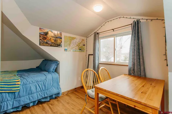 a bedroom with a bed and a table with window