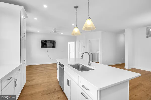 a kitchen with stainless steel appliances granite countertop a sink a microwave oven a refrigerator and white cabinets