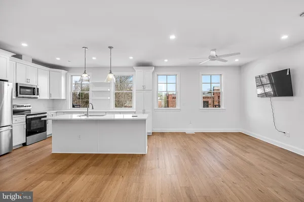 a kitchen with stainless steel appliances granite countertop a stove a sink and a refrigerator