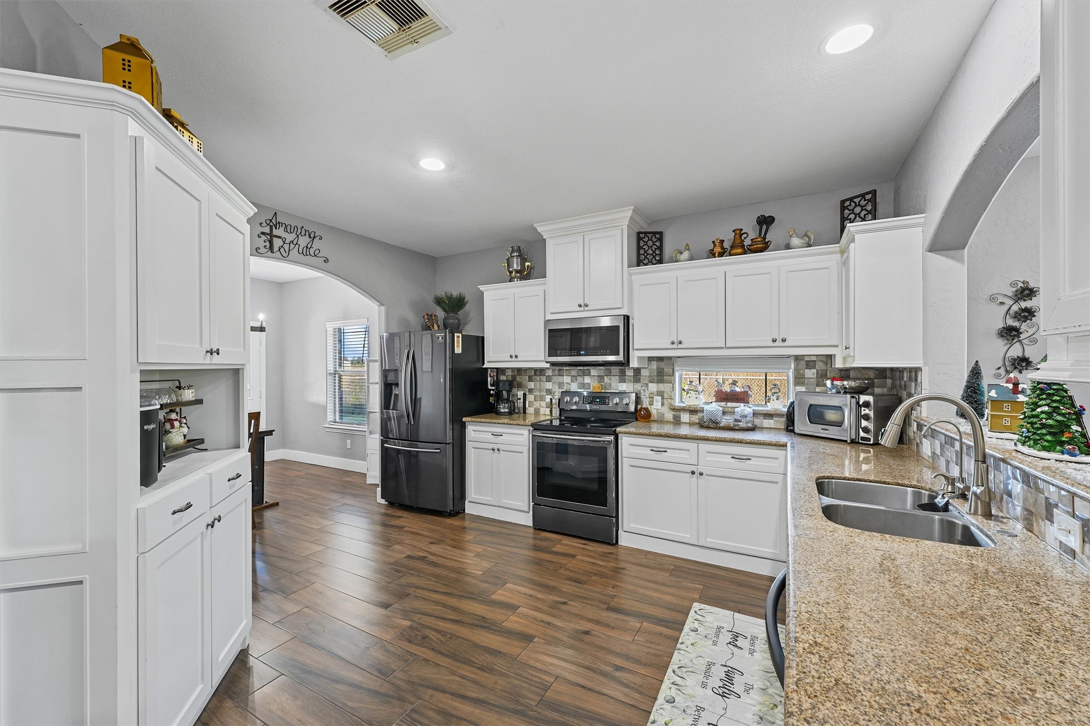 19545 Crosby Eastgate Road Crosby, TX 77532 - Photo 3 of 27 a kitchen with white cabinets and stainless steel appliances