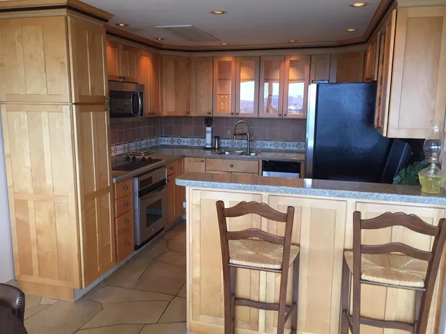 a kitchen with stainless steel appliances granite countertop a stove a sink and a refrigerator