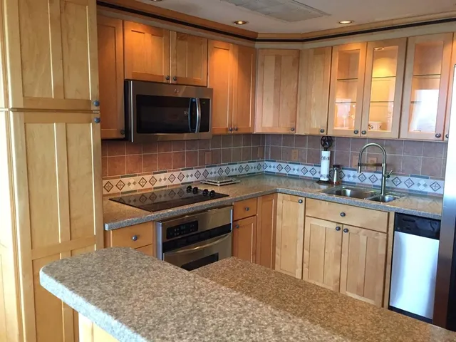 a kitchen with granite countertop a sink stove and microwave