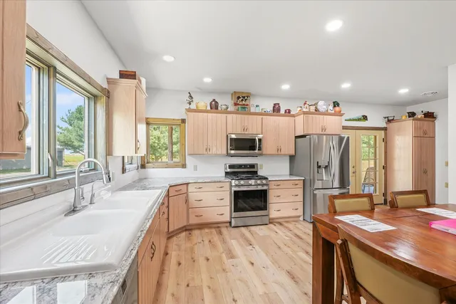 a large kitchen with stainless steel appliances kitchen island granite countertop a large center island and a sink