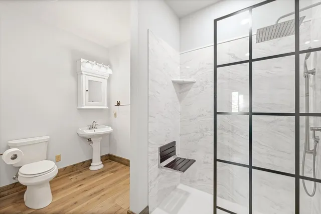 a bathroom with a toilet a sink and mirror