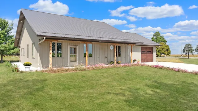 a front view of a house with a garden and yard