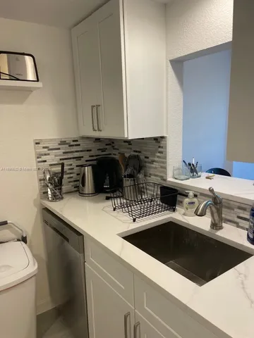 a kitchen with a sink a stove and cabinets