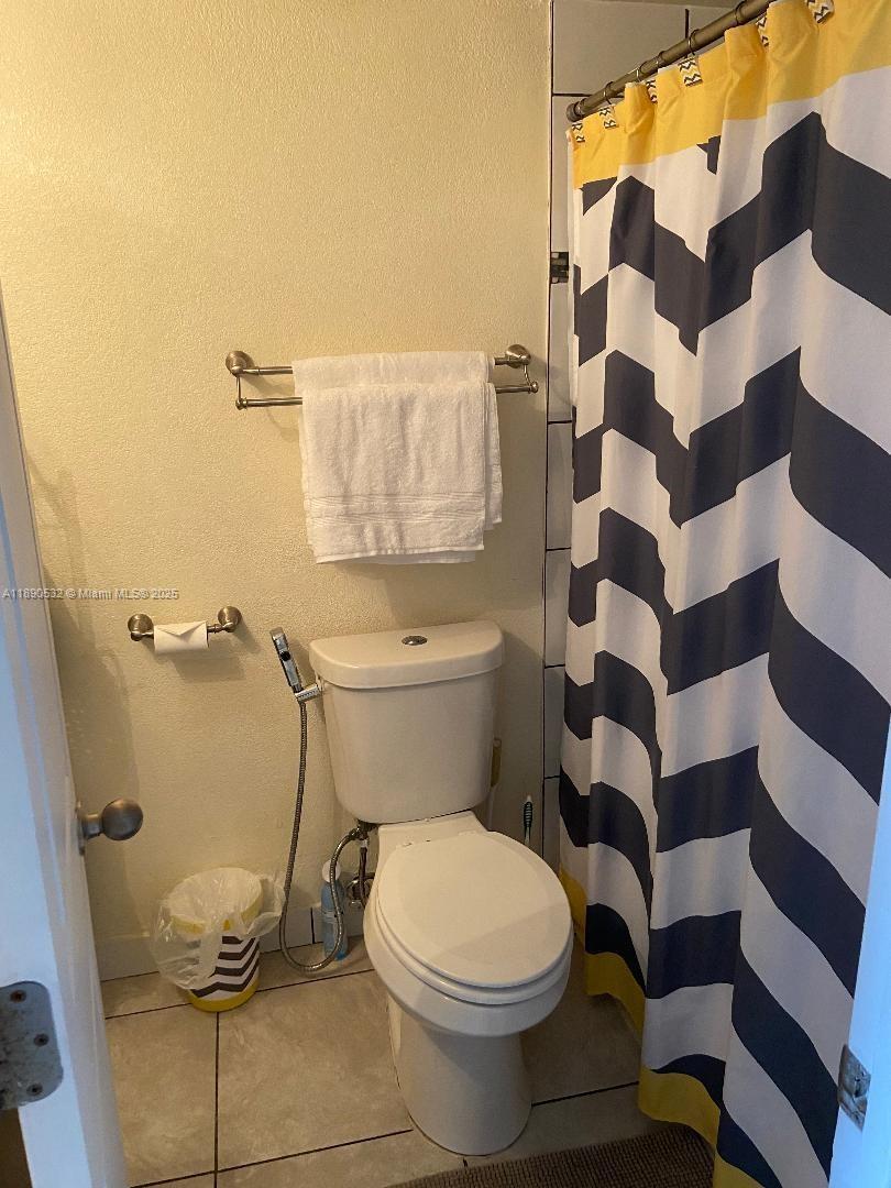 2560 South Ocean Boulevard, Unit 312 Palm Beach, FL 33480 - Photo 14 of 24 a white toilet sitting next to a shower curtain