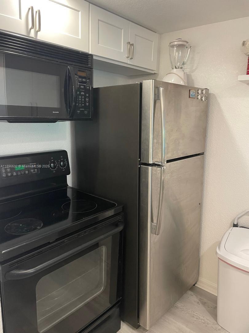 2560 South Ocean Boulevard, Unit 312 Palm Beach, FL 33480 - Photo 10 of 24 a close view of a refrigerator stove and cabinets