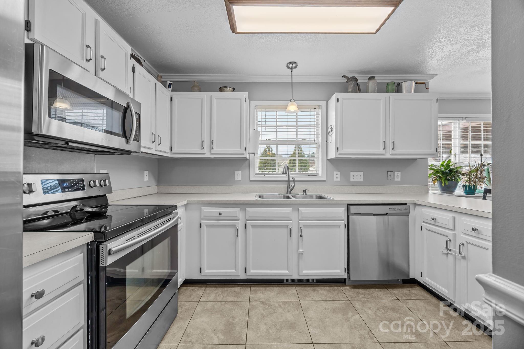 949 Cress School Road Salisbury, NC 28147 - Photo 11 of 46 a kitchen with stainless steel appliances granite countertop white cabinets granite counter tops and a window