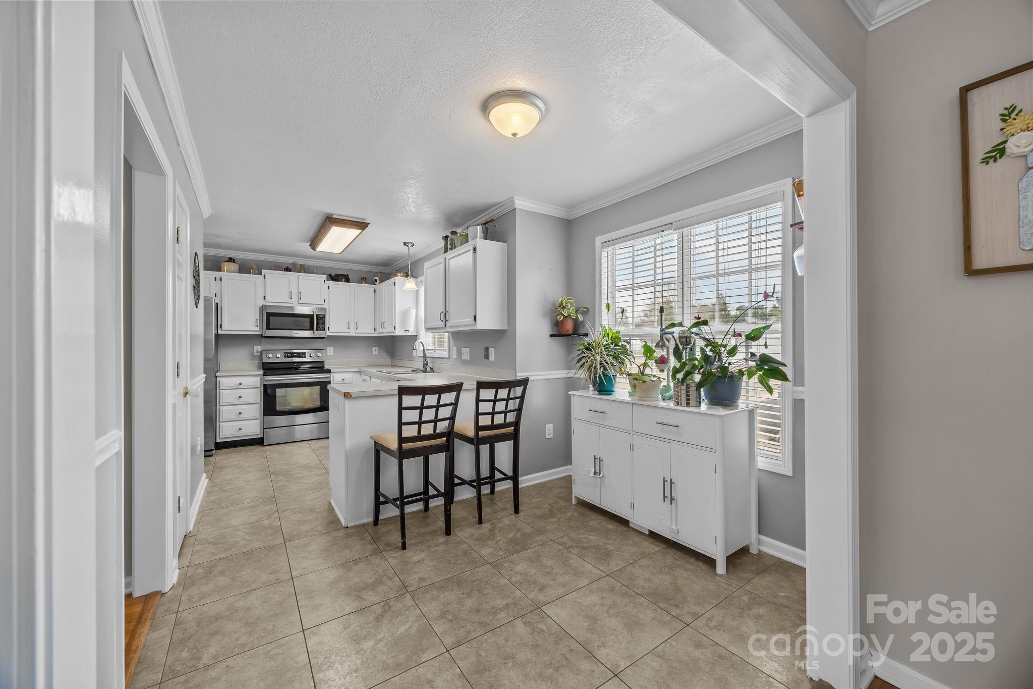 949 Cress School Road Salisbury, NC 28147 - Photo 10 of 46 a kitchen with white cabinets and wooden floor