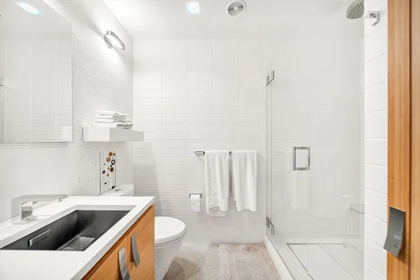 a bathroom with a sink a toilet and shower