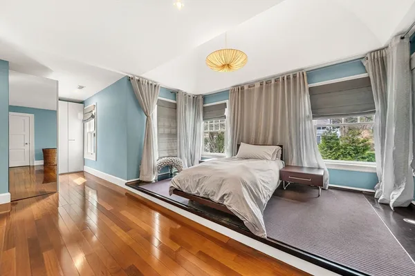 a bed sitting in a spacious bedroom next to a window