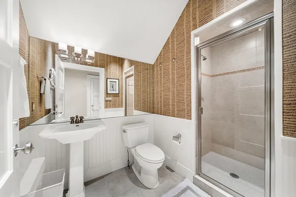 a bathroom with a sink toilet a mirror and shower