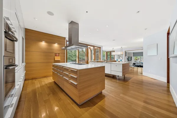 a large kitchen with stainless steel appliances a large counter top a stove and a refrigerator