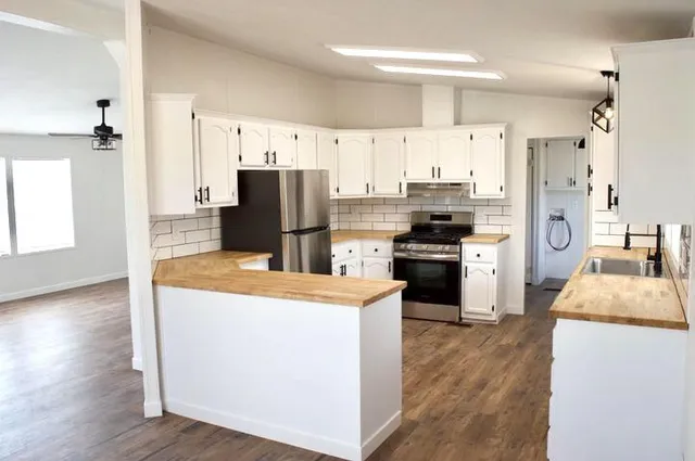 a kitchen with kitchen island a refrigerator stove and sink