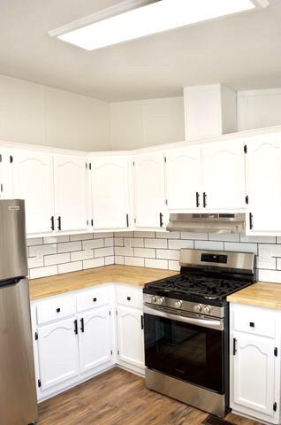 268 County Road Norwood, CO 81423 - Photo 13 of 28 a stove top oven sitting inside of a kitchen with stainless steel appliances wooden floor and cabinets