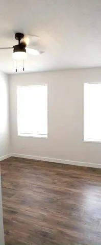 a view of a room with wooden floor and window