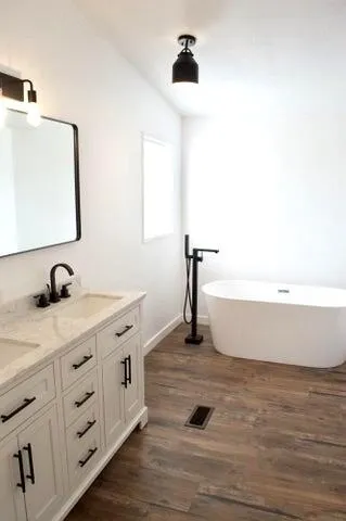 a bathroom with a tub sink and mirror