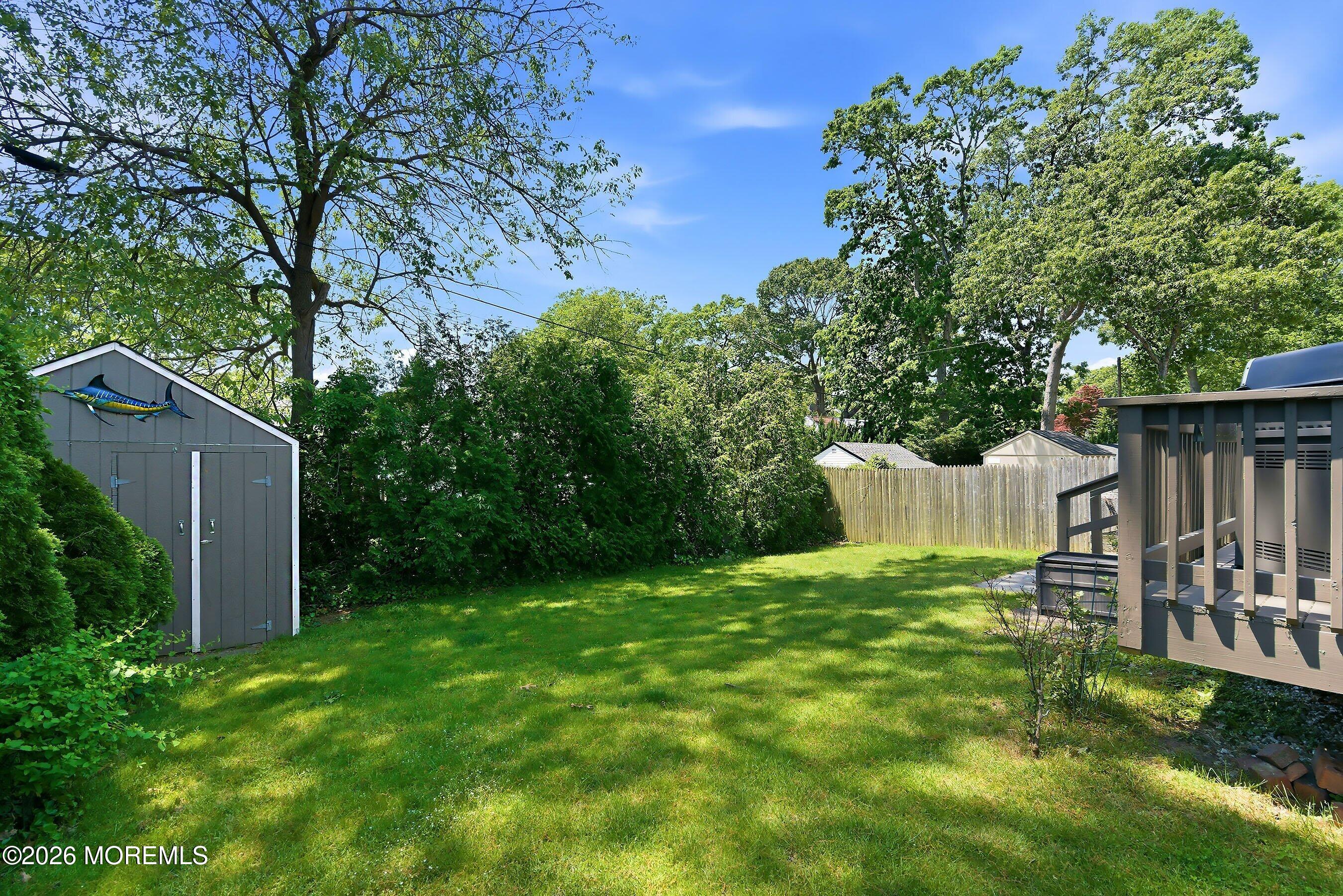 412 Moore Road Neptune Township, NJ 07753 - Photo 31 of 36 a view of a backyard with wooden fence and large trees