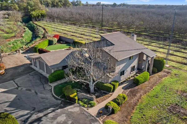 an aerial view of a house with a garden and lake view
