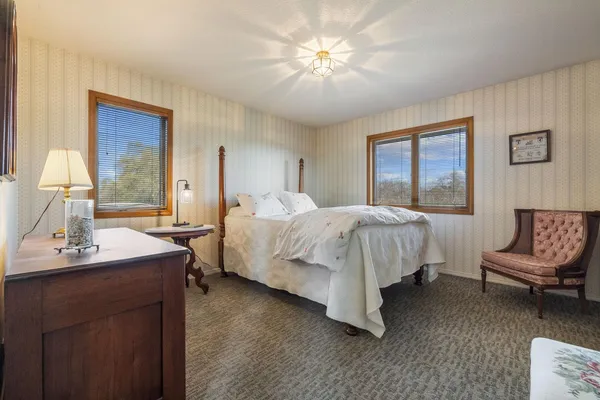 a bedroom with a bed a chandelier and a couch