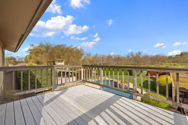 a view of balcony with wooden floor and fence