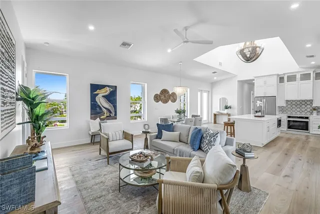 a living room with furniture kitchen view and a window