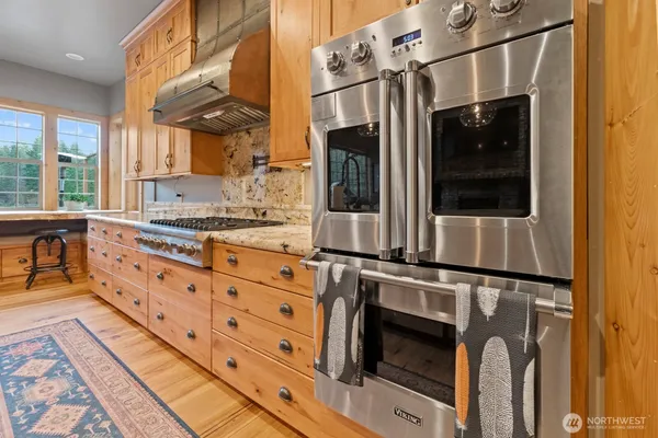 a kitchen with stainless steel appliances granite countertop a sink a stove and a refrigerator