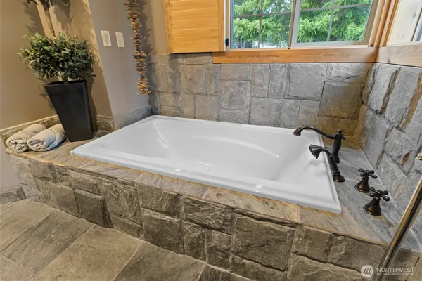 a bathroom with a tub sink and window