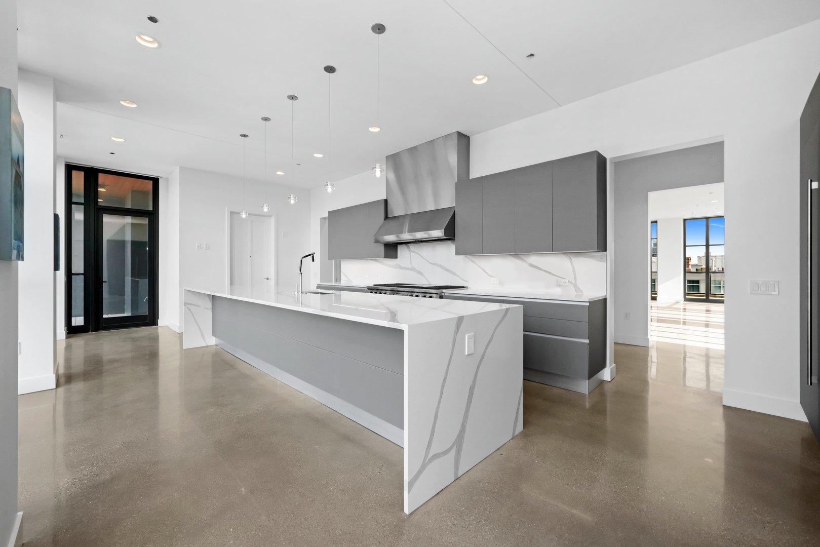 900 West Washington Boulevard, Unit 901 Chicago, IL 60607 - Photo 11 of 20 a large kitchen with stainless steel appliances kitchen island granite countertop a stove a sink and a refrigerator