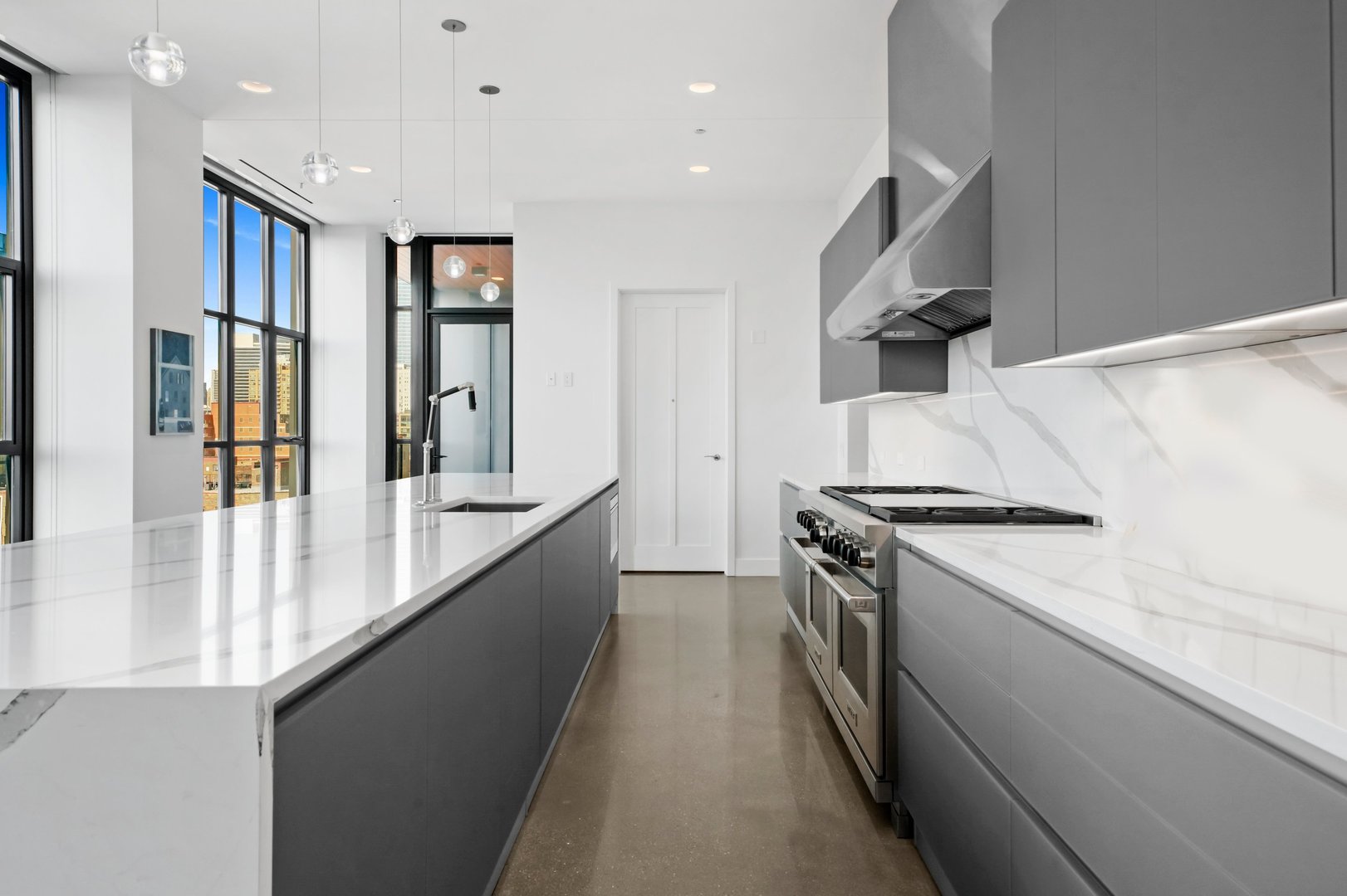 900 West Washington Boulevard, Unit 901 Chicago, IL 60607 - Photo 12 of 20 a large kitchen with stainless steel appliances granite countertop a lot of counter space and a wooden floor