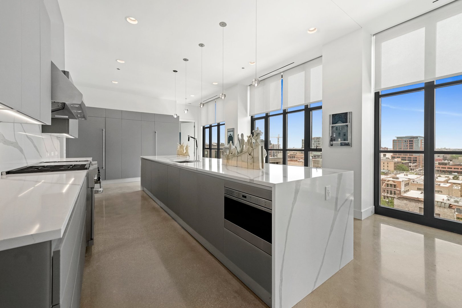 900 West Washington Boulevard, Unit 901 Chicago, IL 60607 - Photo 6 of 20 a kitchen with stainless steel appliances kitchen island granite countertop a refrigerator and a stove top oven