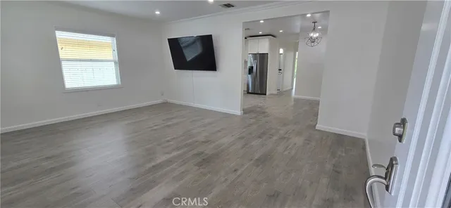 an empty room with wooden floor and a window