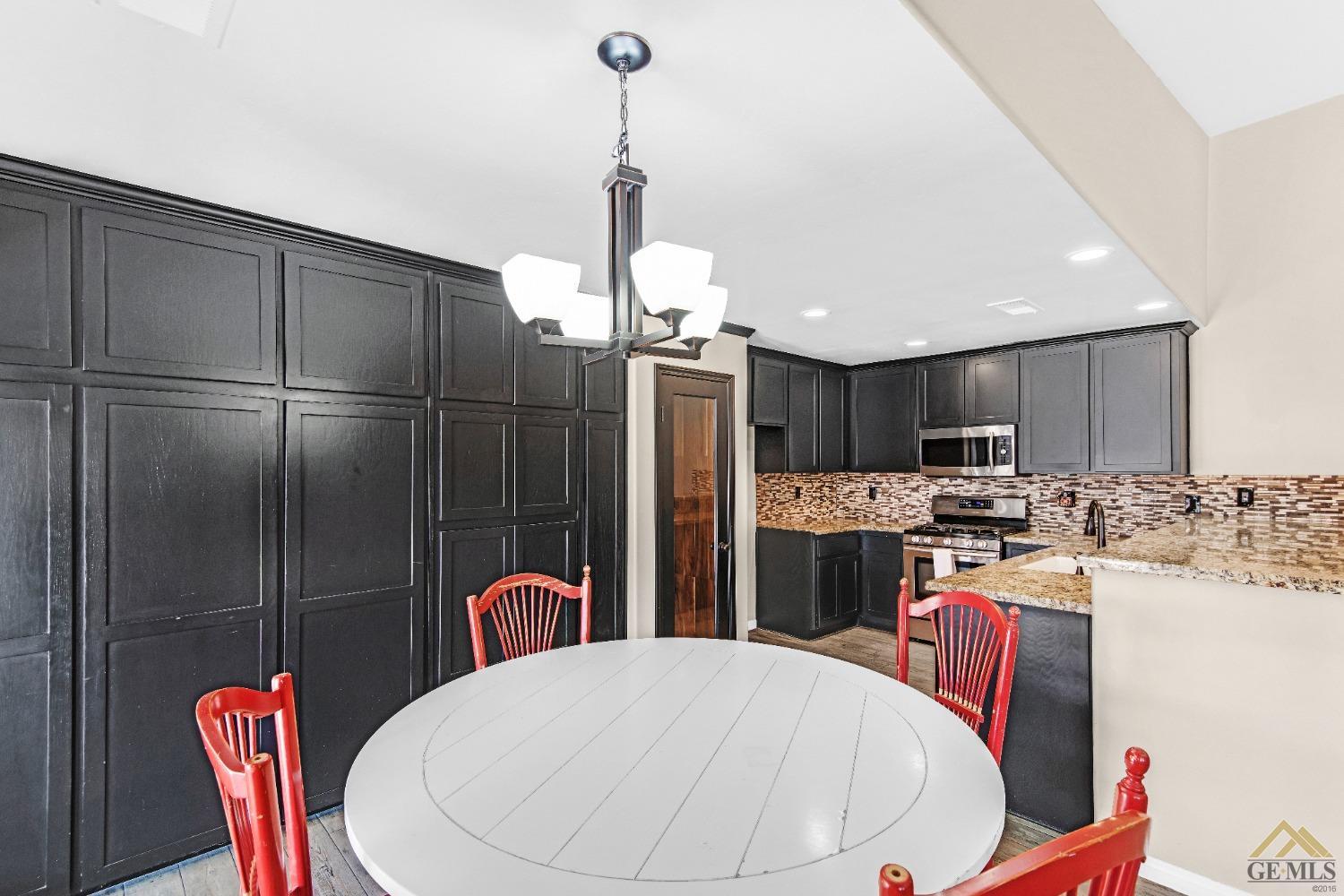 Undisclosed Address Bakersfield, CA 93312 - Photo 11 of 31 a kitchen with stainless steel appliances kitchen island granite countertop a refrigerator a stove a sink dishwasher with a dining table and chairs