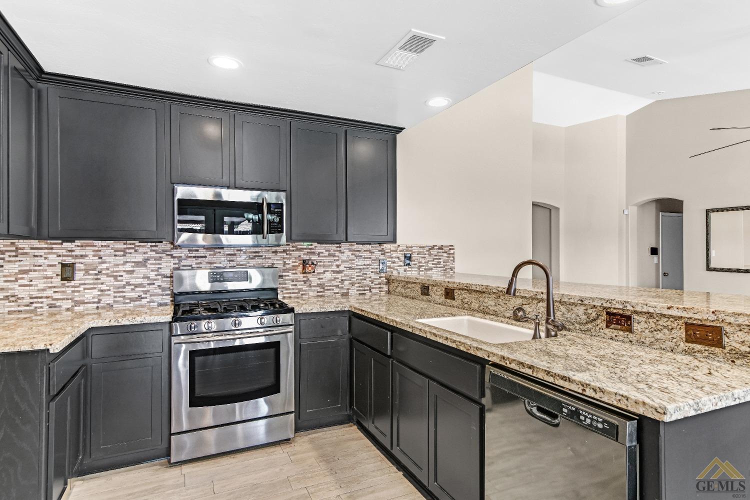 Undisclosed Address Bakersfield, CA 93312 - Photo 13 of 31 a kitchen with a sink stove and microwave