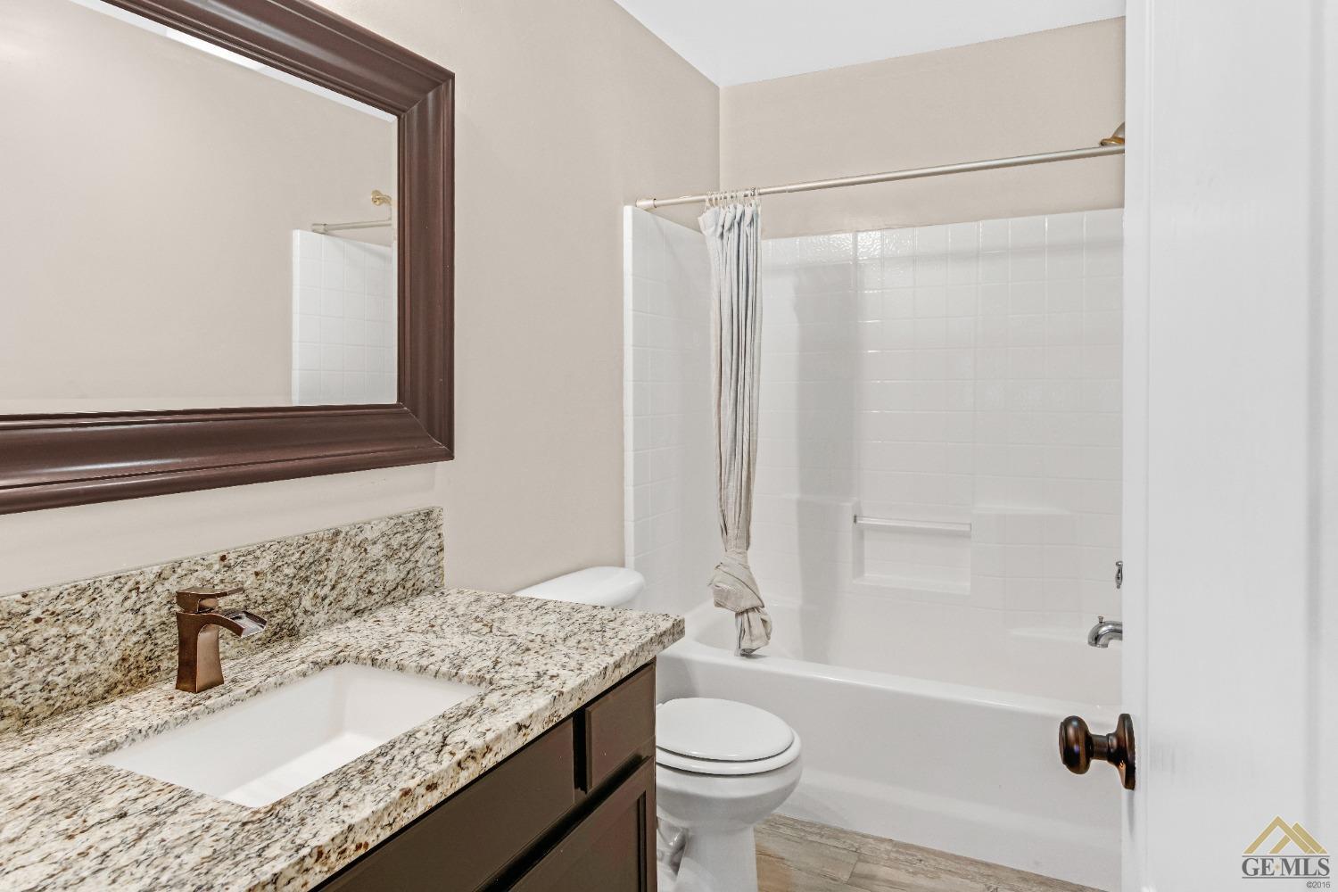 Undisclosed Address Bakersfield, CA 93312 - Photo 25 of 31 a bathroom with a granite countertop sink mirror toilet and bathtub