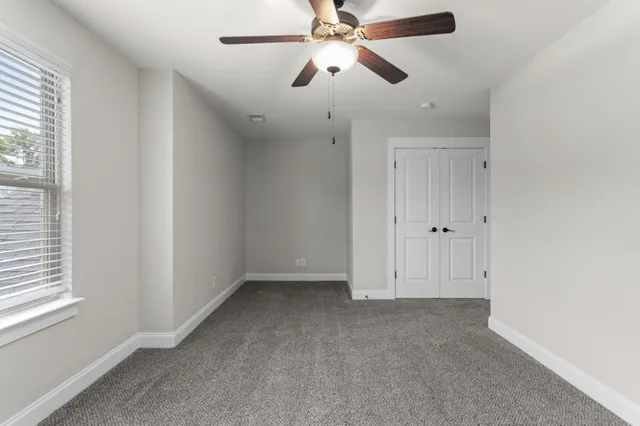 an empty room with a window and a fan