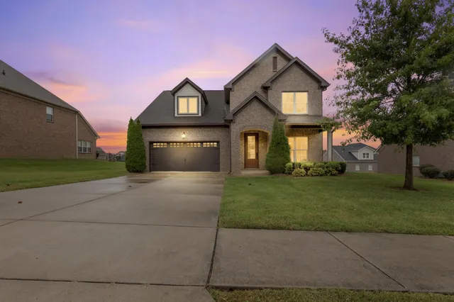 a front view of a house with a yard and garage