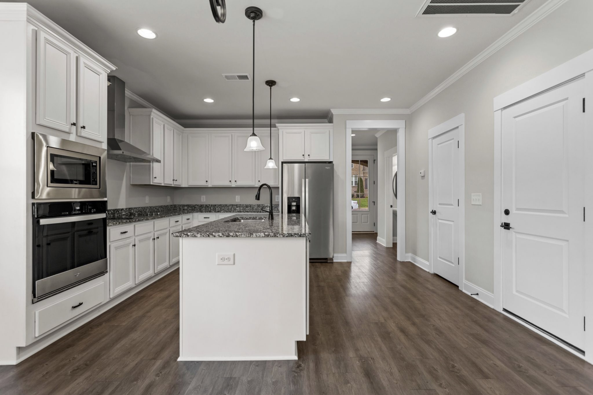 6091 Kidman Lane Spring Hill, TN 37174 - Photo 9 of 43 a kitchen with stainless steel appliances kitchen island granite countertop a refrigerator a oven a sink and white cabinets with wooden floor