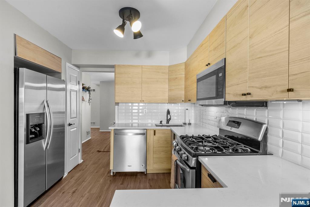 23 Bayowski Road, Unit 149 West Orange, NJ 07052 - Photo 6 of 38 a kitchen with stainless steel appliances granite countertop a stove a refrigerator and a microwave