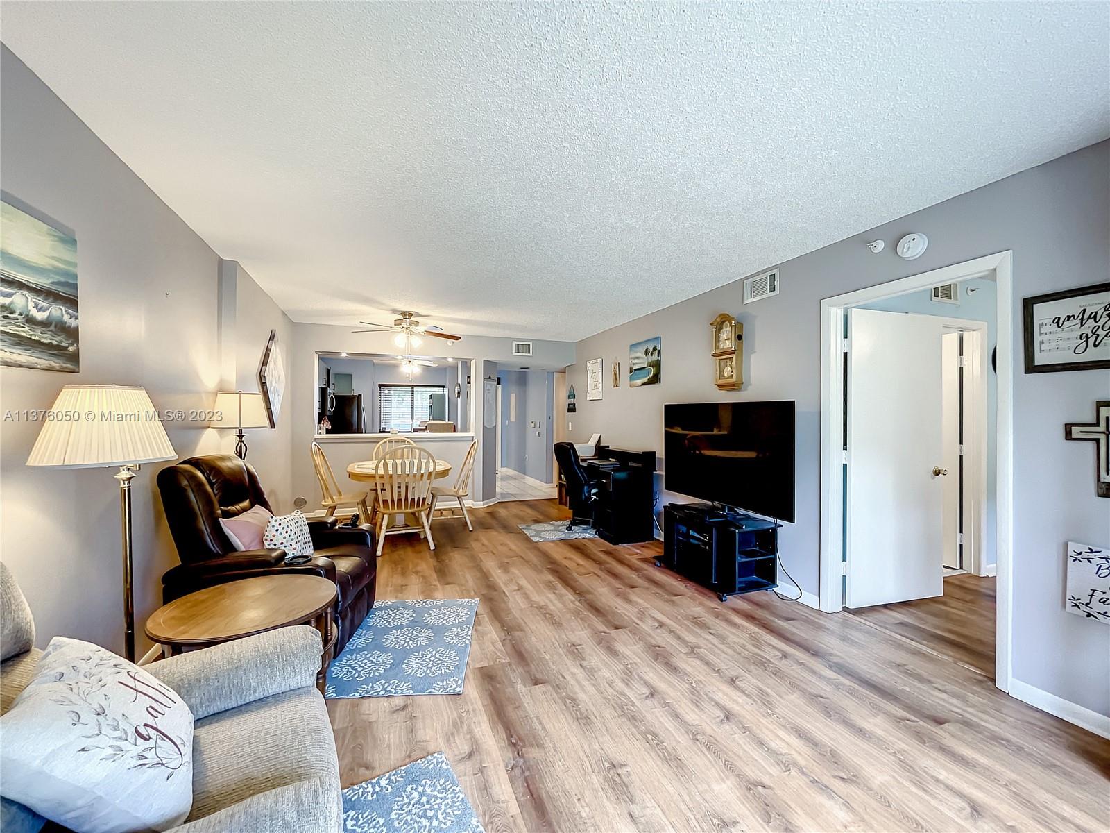 9580 Weldon Circle, Unit K110 Tamarac, FL 33321 - Photo 16 of 37 a living room with furniture and a flat screen tv