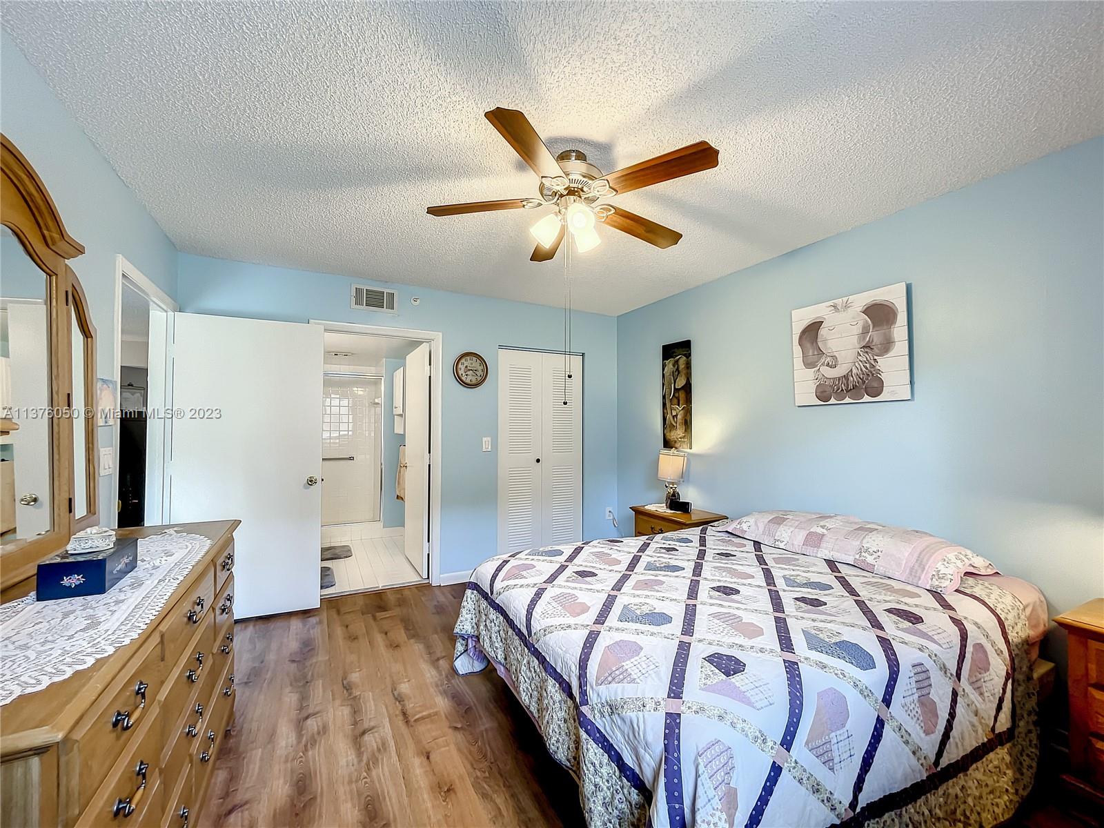 9580 Weldon Circle, Unit K110 Tamarac, FL 33321 - Photo 22 of 37 a bedroom with a bed and a chandelier