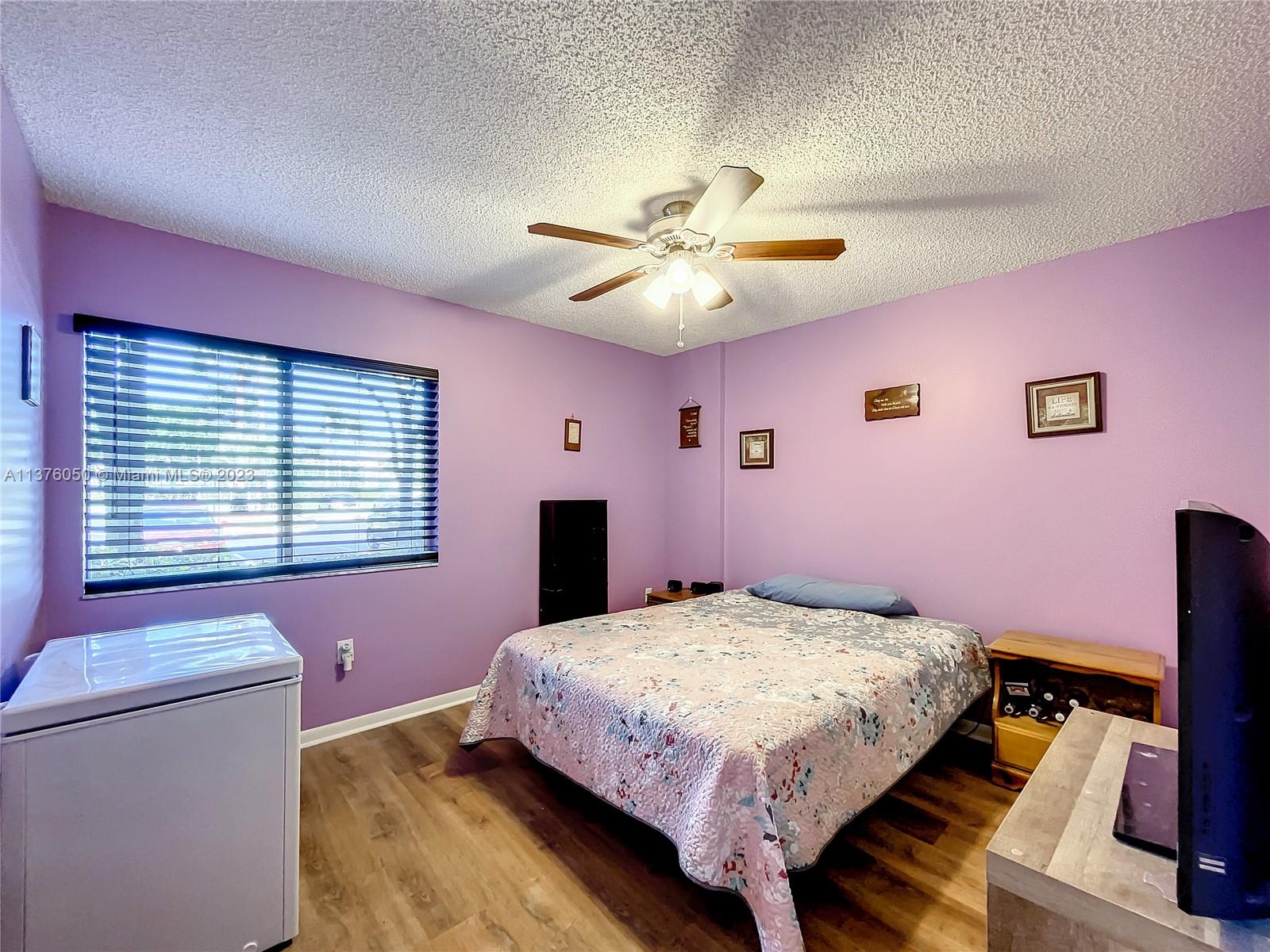 9580 Weldon Circle, Unit K110 Tamarac, FL 33321 - Photo 24 of 37 a bedroom with a bed and a chandelier