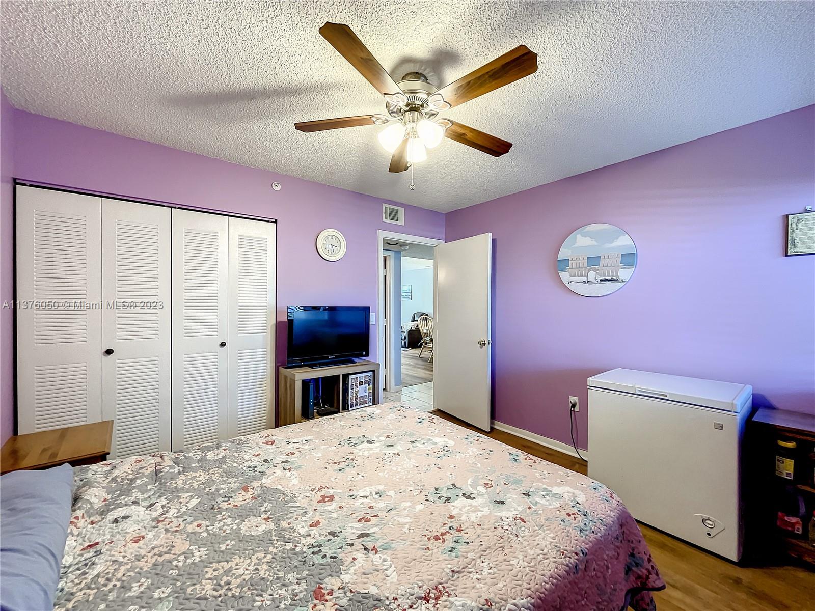 9580 Weldon Circle, Unit K110 Tamarac, FL 33321 - Photo 25 of 37 a bedroom with a bed and a flat screen tv