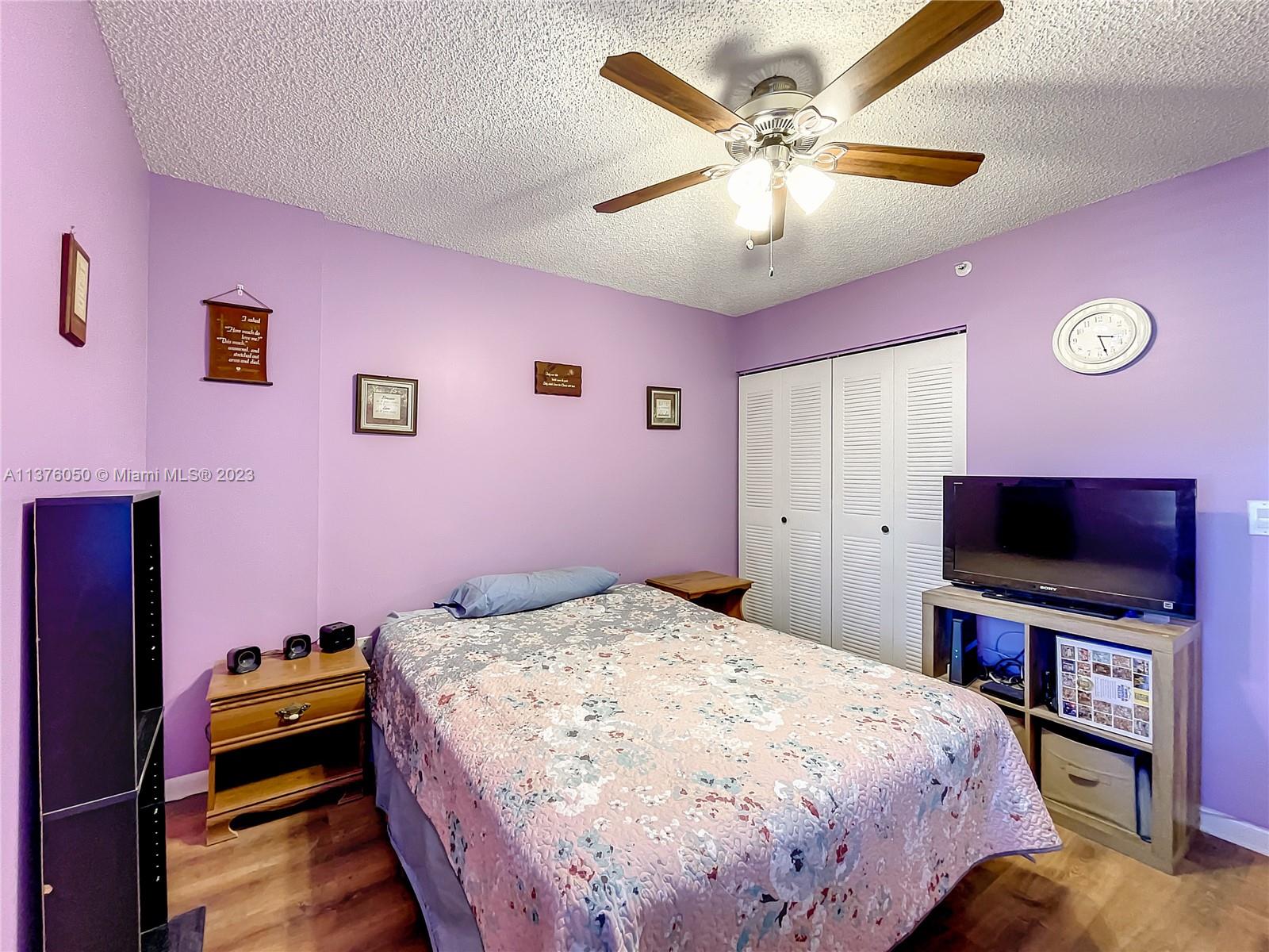 9580 Weldon Circle, Unit K110 Tamarac, FL 33321 - Photo 26 of 37 a bedroom with a bed and a flat screen tv
