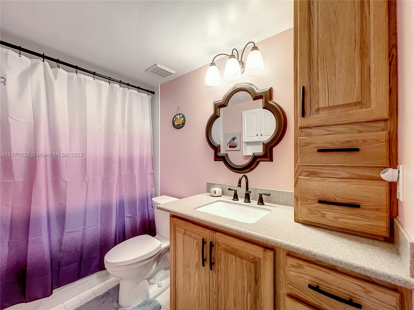 9580 Weldon Circle, Unit K110 Tamarac, FL 33321 - Photo 28 of 37 a bathroom with a sink a toilet and a mirror