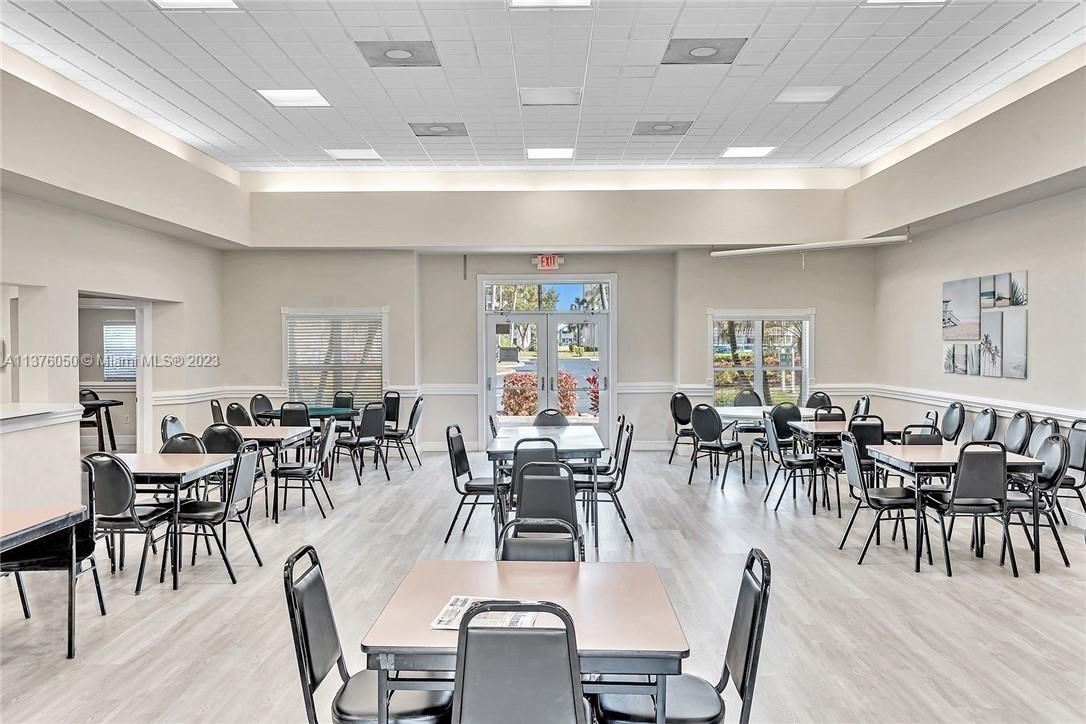 9580 Weldon Circle, Unit K110 Tamarac, FL 33321 - Photo 32 of 37 a dining room with lots of furniture and wooden floor