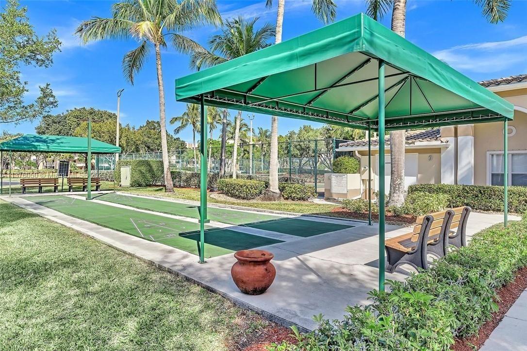 9580 Weldon Circle, Unit K110 Tamarac, FL 33321 - Photo 35 of 37 a view of a table and chairs under an umbrella