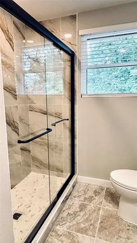 a bathroom with a toilet and a large window