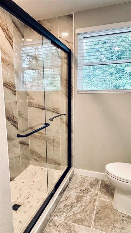 4603 Junius Street, Unit 9 Dallas, TX 75246 - Photo 6 of 9 a bathroom with a toilet and a large window